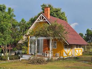 ein kleines gelbes Haus mit rotem Dach in der Unterkunft ไอหมอก ชาเล่ต์ in Wang Nam Khieo