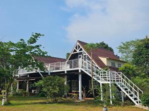 a house with a staircase on the side of it at ไอหมอก ชาเล่ต์ in Wang Nam Khieo