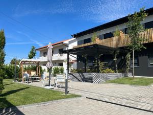 a building with a patio with an umbrella and a table at Alma Candida 11 in Valença