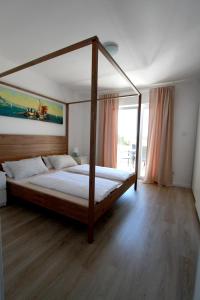 1 dormitorio con cama con dosel en una habitación en Apartments Casa Barbara, en Rab