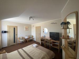 a hotel room with a bed and a dining room at Motel Orion in Piła