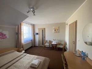 een hotelkamer met een bed en een tafel en stoelen bij Motel Orion in Piła