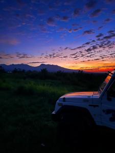 a white truck parked in a field at sunset at Raturinjani homestay in Selong