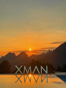 um sinal que diz uau em frente a um pôr-do-sol em XMAN Valley Sunrise Resort em Zhangjiajie