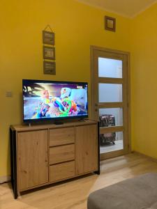 a flat screen tv sitting on top of a wooden entertainment center at Soucis au vent 2 in De Panne