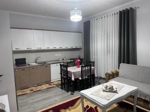 a kitchen and a living room with a table at Erdi's Home in Berat