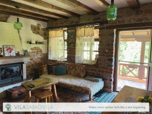 a living room with a couch and a fireplace at Traditional Cottage - Vila Samovila in Delčevo