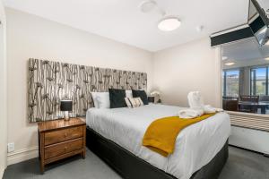 ein Schlafzimmer mit einem großen Bett und einem Fenster in der Unterkunft The Beacon - 2 Bedroom Town Center Apartment in Queenstown