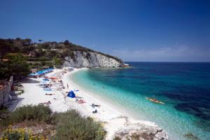 a beach with a bunch of people and the ocean at Residence Capobianco in Portoferraio