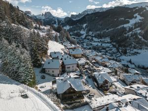 un pueblo en las montañas cubierto de nieve en Enjoy Dolomites - Chalet, en Santa Cristina Valgardena