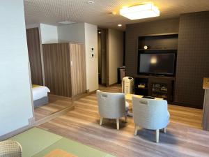 箱根的住宿－月野薩拉酒店，酒店客房配有电视、桌子和椅子。