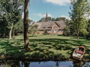 a boat sitting on the grass in front of a house at NordseeEstate - Loft unter Reet mit Sauna in Tetenbüll