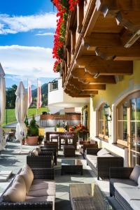 a patio with couches and tables and flowers at Hotel Kristall in Grossarl