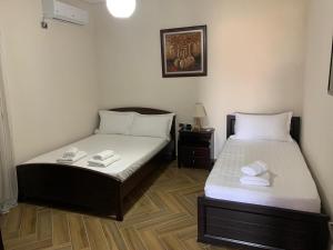 - 2 lits dans une petite chambre avec jupes dans l'établissement Davi Apartments, à Ksamil