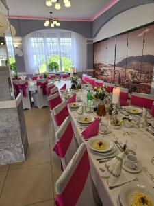 een eetkamer met witte tafels en rode stoelen bij Motel Orion in Piła