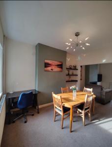 uma sala de jantar com mesa e cadeiras e uma secretária em Victorian Semi Detached House behind the High Street em Newton in Makerfield