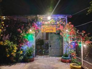 a house covered in christmas lights and flowers at BONNIE HOMESTAY Mui Ne in Mui Ne