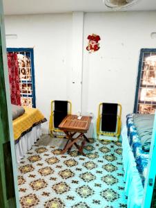 美奈的住宿－BONNIE HOMESTAY Mui Ne，一间设有两张床和一张桌子及椅子的房间