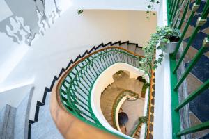 a spiral staircase in a building with a plant at White Wolf House Hostel & Apartments in Prague