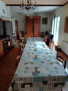 a long table in a room with a table cloth on it at Maison de campagne avec piscine in Le Blanc