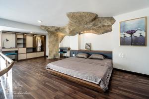 - une chambre avec un grand lit et un plafond en pierre dans l'établissement KunKin Garden Aparthotel, à Hô-Chi-Minh-Ville