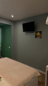 a bedroom with a bed and a flat screen tv at Evergreen Apart in Almaty