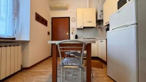クレモナにあるAppartamenti I Liutaiのキッチン(白い冷蔵庫、椅子付)