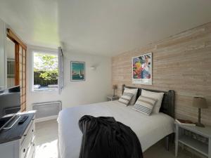 a bedroom with a bed and a kitchen with a window at Villa de la Cible in Saint-Martin-de-Ré