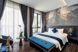 a bedroom with a large bed and a blue bench at KunKin Garden Aparthotel in Ho Chi Minh City
