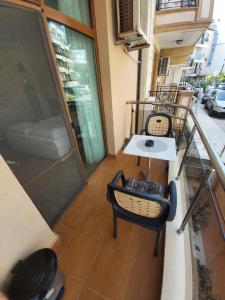 a balcony with two chairs and a table on a building at Guest House Skalite in Sozopol