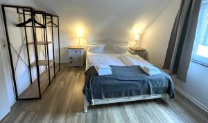 a bedroom with a bed with two night stands and two lamps at Peters Aparthotel in Goslar +49 photos