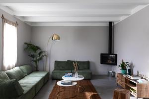 ein Wohnzimmer mit einem grünen Sofa und einem Tisch in der Unterkunft El Patio in San Vito Rimini