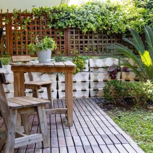 patio con tavolo e sedie in legno e recinzione di The Garden House at Alimos ad Atene