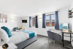 Schlafzimmer mit einem Bett und einem Schreibtisch in der Unterkunft Pluxa Globe - Spacious Apartment in JQ with parking in Birmingham