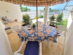 einen Tisch mit Stühlen und einem Sonnenschirm auf einer Terrasse in der Unterkunft Villino Costa del Porto in Porto Cesareo