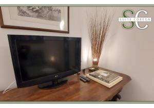 ein Fernseher mit einem Buch auf einem Holztisch in der Unterkunft Suite Cobega Appartamento in centro città in Taranto