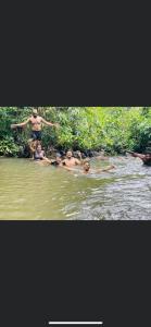 a group of people are in the water at Niwana Resorts kiriella in Kiriella