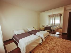 a bedroom with two beds and a mirror at Sweet House in Solesino