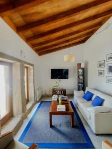 sala de estar con sofá blanco y techo de madera en Casa do Fieiro, en Miñortos