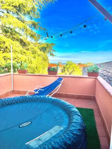 a swimming pool with a chair and an umbrella at Linden House Etna in Aci SantʼAntonio
