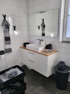 a white bathroom with a sink and a mirror at Elseblick in Schüttorf +29 photos