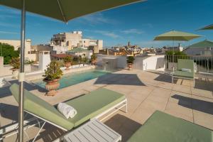 a balcony with a pool and chairs and an umbrella at Palazzo Matteo in Nardò