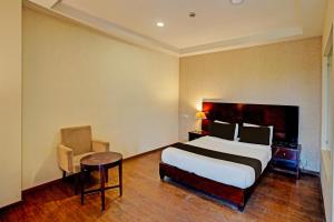 een slaapkamer met een bed, een tafel en een stoel bij Townhouse 1339 Hotel Anamika Enclave in Gurgaon