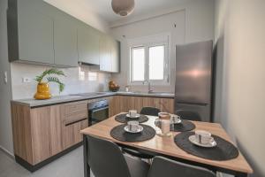 a kitchen with a wooden table with chairs in it at Kos Cozy Home in Kos