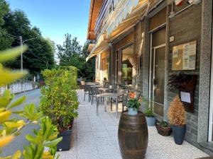 an outdoor patio with tables and chairs and plants at Albergo LA COLDRA in Quarona