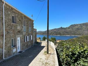 a stone building with a view of a lake at Casa do Beija in Outeiro