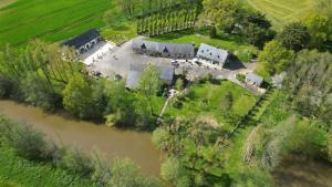 an aerial view of a house next to a river at La grange de l'épine in Forges-la-Forêt