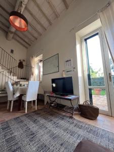 a living room with a table and a television at Le case di Anita in Toscana -Capalbio in Capalbio