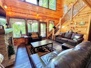 ein Wohnzimmer mit einem Sofa und einem Tisch in einer Hütte in der Unterkunft South Side Serenity Cabin in Sevierville