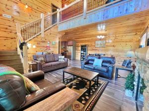 ein Wohnzimmer mit Ledermöbeln und einer Holzwand in der Unterkunft South Side Serenity Cabin in Sevierville